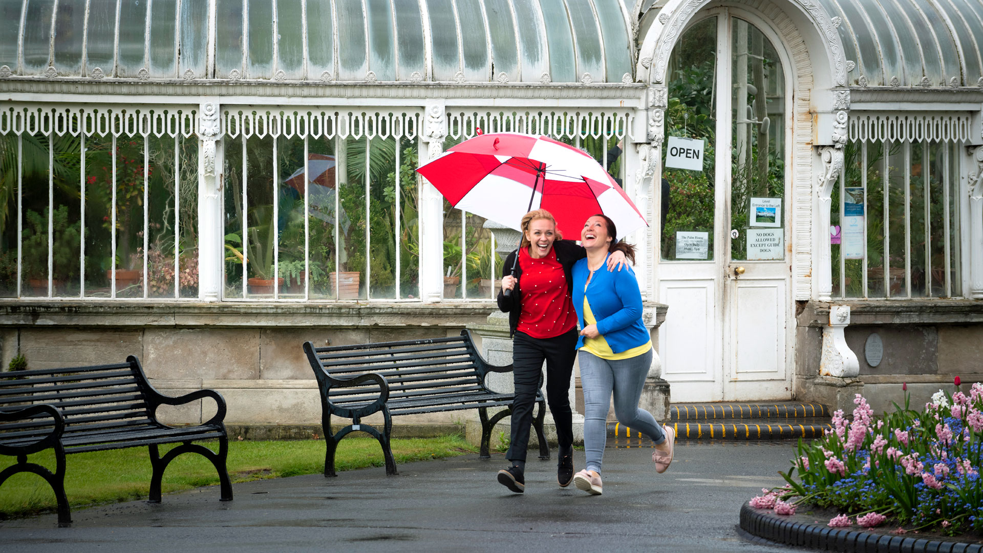 girls running in the rain under an umberella at botanic gardens 